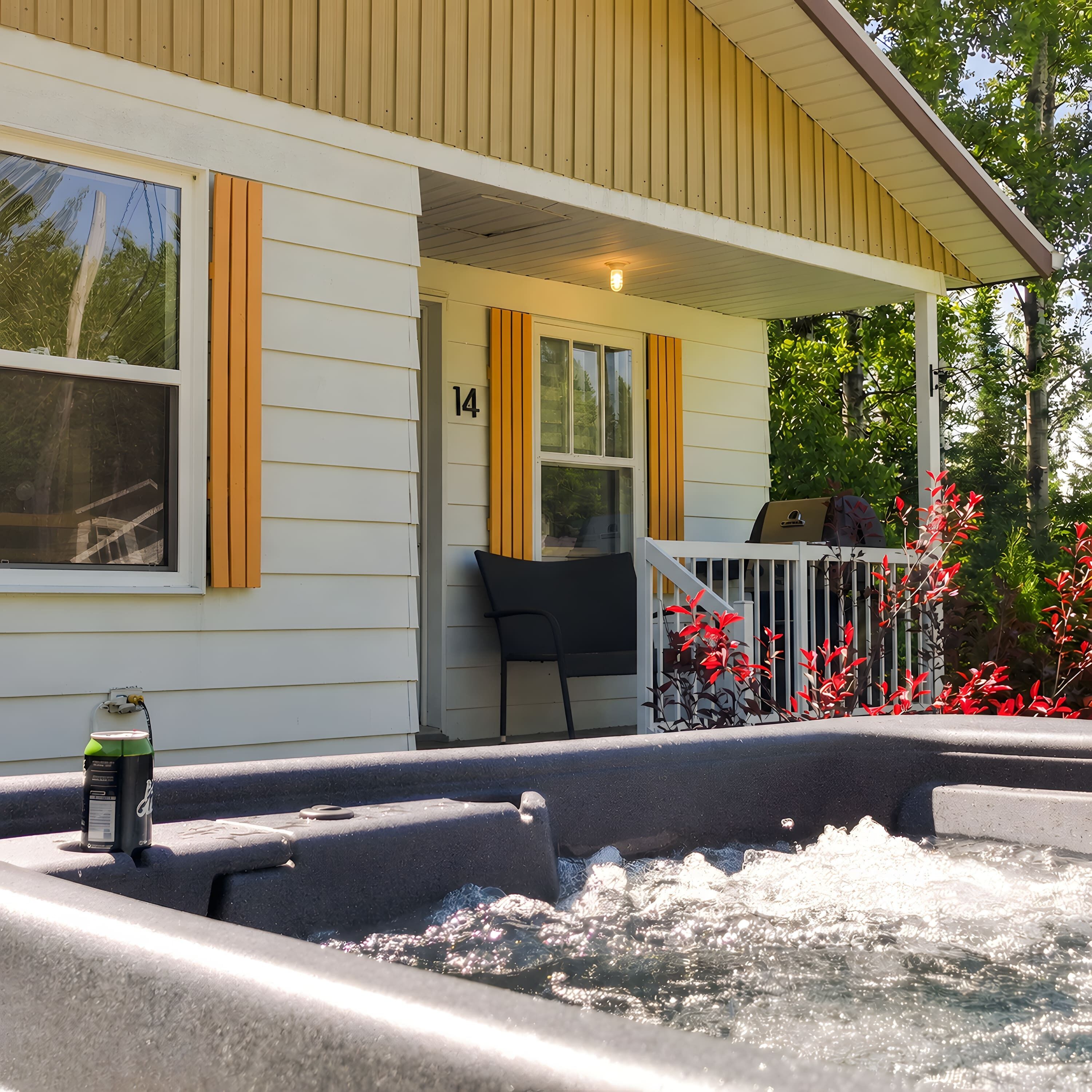 Et hus med veranda, jacuzzi og et skilt med nummer 14.