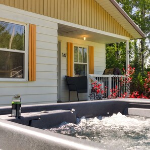 Een huis met veranda, een jacuzzi en een nummer 14 bord.