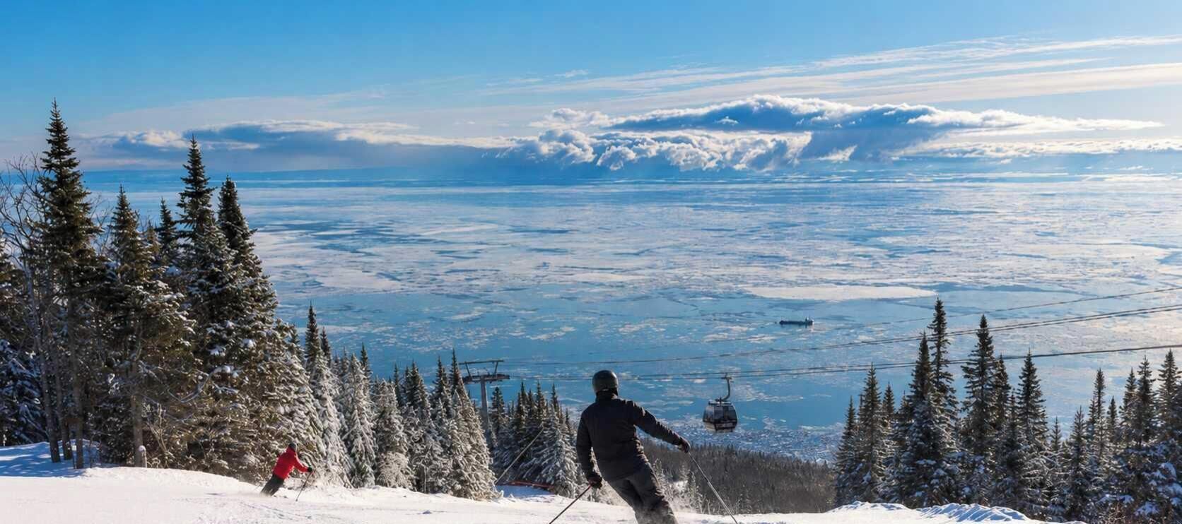 A snowy mountain landscape with a ski lift and a person skiing.