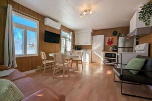 Un espacio habitable compacto con comedor, kitchenette y sofá.