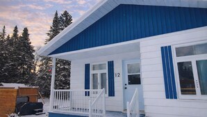 Un edificio a due piani con facciata blu e decorazioni bianche.