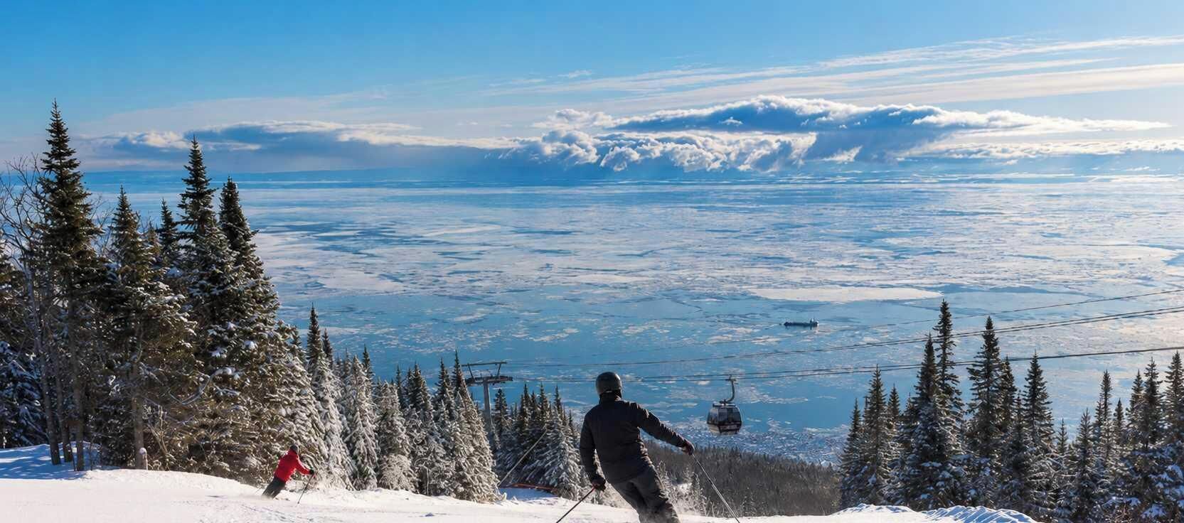 A snowy mountain landscape with a ski lift and a person skiing.