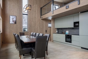 A modern kitchen with grey cabinets, a black oven, and a stainless steel microwave.