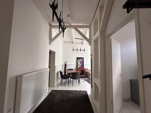 A hallway with a radiator, a dining table with chairs, and a painting on the wall. - First floor apartment in the old town of Sassnitz (Sassnitz)