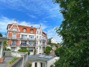 A multi-story building with a red-tiled roof, balconies, and a garden area. - First floor apartment in the old town of Sassnitz (Sassnitz)
