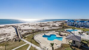 A resort with a beach view, a pool area, and a building with blue roofs. - Gulf Shores Plantation, 5508 - Beachfront Condo with Gulf Views (Gulf Shores)