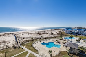 Ein Resort mit Blick auf den Strand, einem Poolbereich und einem Gebäude mit blauen Dächern.