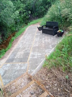 A paved pathway with a bench and planter.