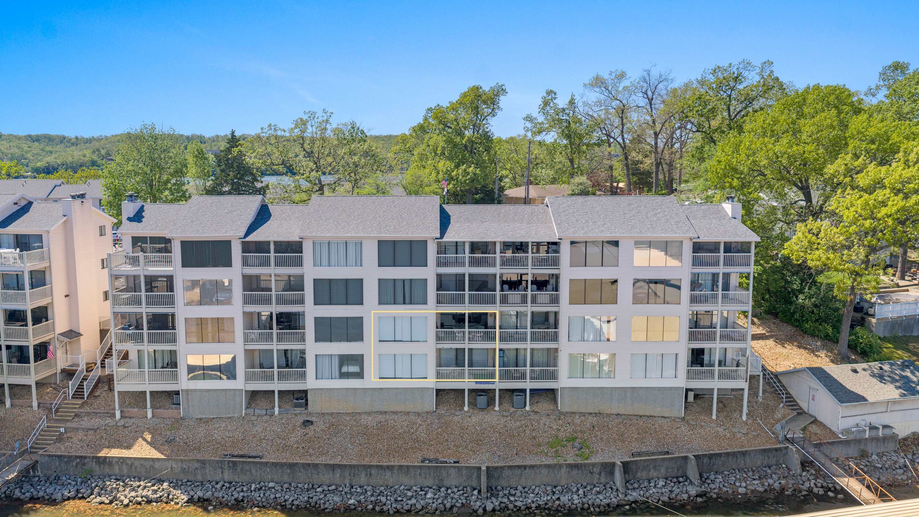 A multi-story hotel with balconies, a pool area, and a view of the surrounding landscape.