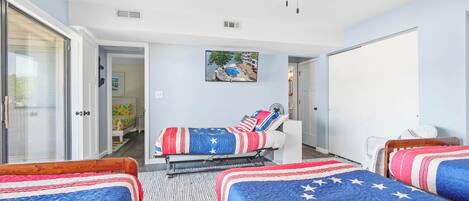 A bedroom with two beds, a ceiling fan, and a painting of a landscape.