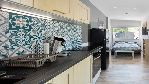Una cocina moderna con un salpicadero estampado, armarios de madera y una zona de comedor con banco.