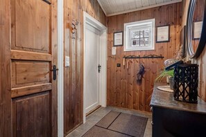 A wooden interior hallway with a door, a window, and a wall-mounted plaque. - TH589 Ski-in/Out Cabin, Sauna, 13 Guests (Trysil)