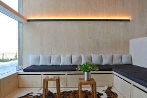 A room with a built-in bench, a small table with a plant, and a cowhide rug. - Trysilfjell hytteområde 2027 by Vacation Trysil (Trysil)
