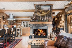 A rustic interior with a fireplace, wooden furniture, and a dining area. - TH587- Premium Ski-inout Chalet, 4 Bed, 4 Bath (Trysil)