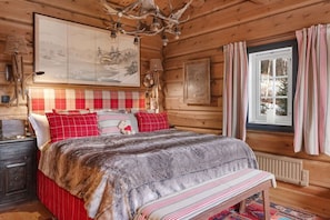 A wooden cabin bedroom with a bed, bench, window, and artwork. - TH587- Premium Ski-inout Chalet, 4 Bed, 4 Bath (Trysil)