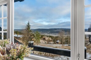 A view from a window with a wooden railing, overlooking a snowy landscape with trees and distant hills. - TH587- Premium Ski-inout Chalet, 4 Bed, 4 Bath (Trysil)