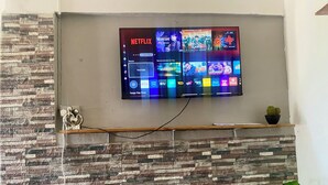 Una TV a schermo piatto montata a parete con decoro a effetto pietra sotto.