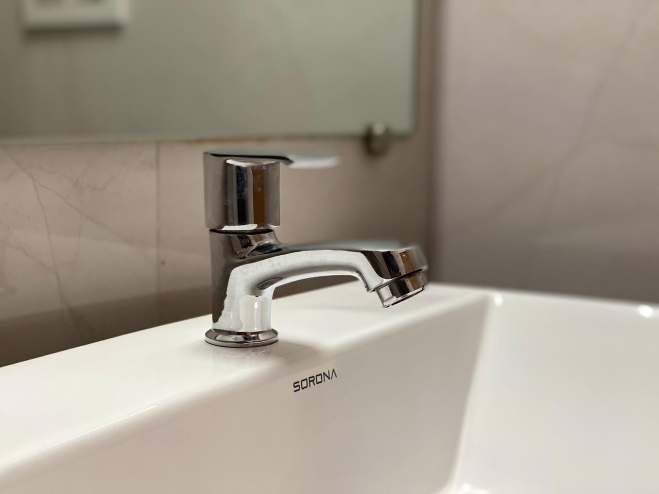 A white sink with a chrome faucet and the brand name "SORONA" visible on the sink.