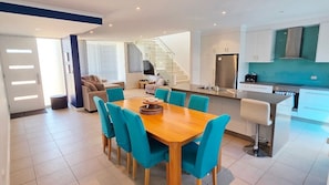 A modern apartment with a dining area, kitchen, and living space.