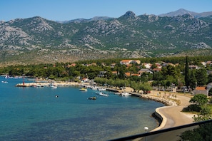 Une ville côtière dotée d’un port de plaisance, de maisons et, en arrière-plan, de montagnes.