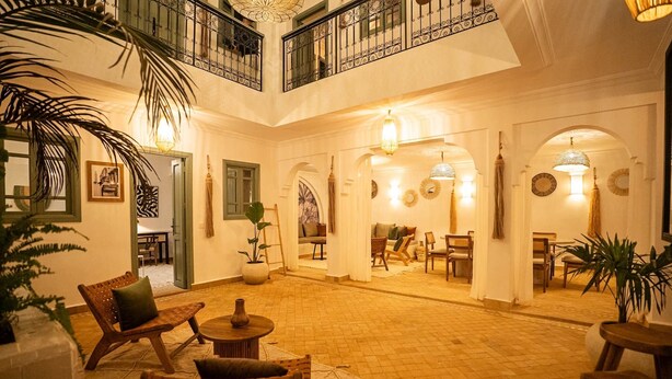 Eine großzügige Lobby mit hoher Decke, einem Balkon und einem Essbereich.