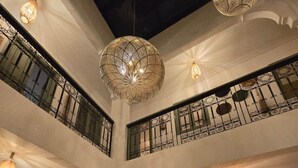 Ein mehrgeschossiges Interieur mit aufwendigen Kronleuchtern, einem Essbereich und einer Treppe.
