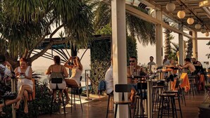 An outdoor dining area with tables and chairs, surrounded by greenery and palm trees. - Terra Royal - Luxury Apartment & Hotel in Ho Chi Minh City (Thành phố Hồ Chí Minh)