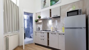 Een moderne keuken met een inbouwoven, magnetron en koelkast.
