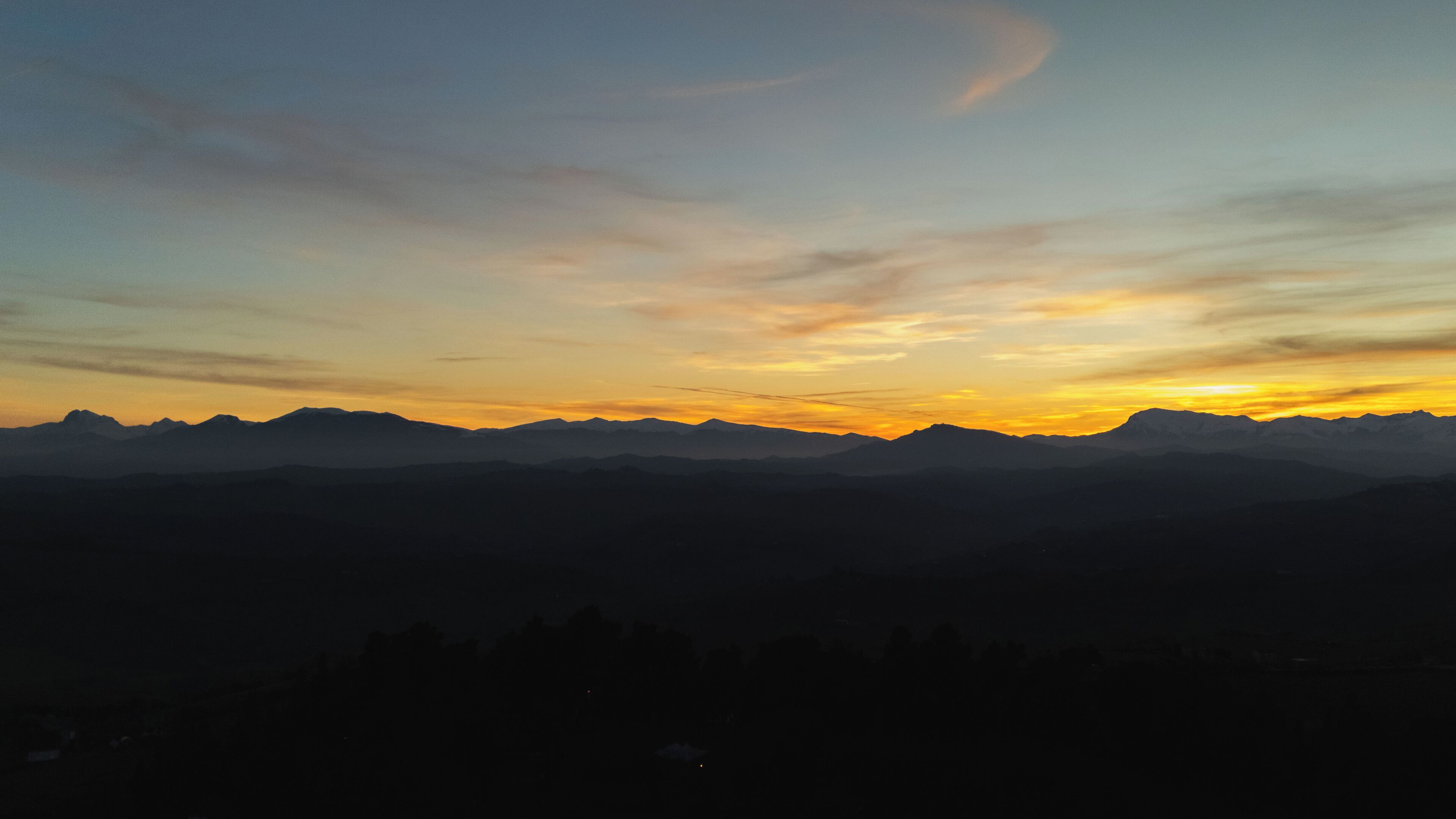 La silhouette d’une chaîne de montagnes se détachant sur le ciel au coucher du soleil.