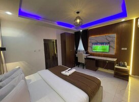 Habitación de hotel con cama, escritorio, televisión y vistas a la ciudad.