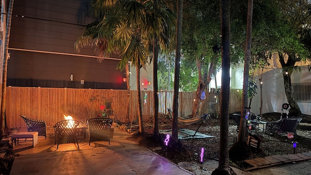 An outdoor patio area with a fire pit, seating, and a hammock. - Biscayne Hideaway- 3 bed house Miami Big Yard Driveway - Downtown/Wynwood - FIFA (Miami)