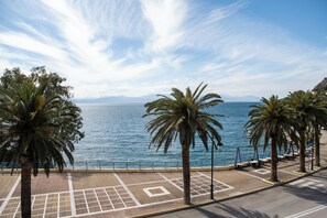 A coastal promenade with palm trees, a clear sky, and a view of the sea. - GET Seaside Vibe Apartments Loutraki (Loutraki)