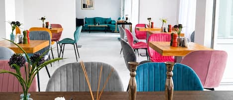 Una sala moderna con un sofá, sillas, una mesa de centro y un comedor con una mesa y sillas.