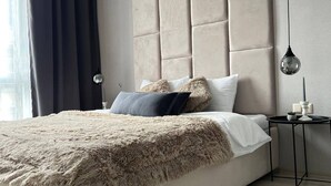 A modern bedroom with a large bed, a headboard, a bedside table, and a lamp. - Room-sunny Beach Central Apartment - 4 G (Nessebar)