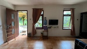 A room with a TV, a water dispenser, a bed, and a door leading outside. - Masada Village (Cisarua)