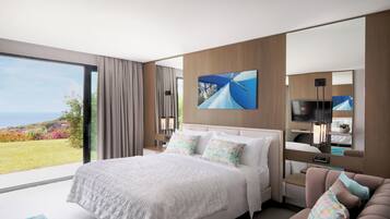 Una camera d'albergo moderna con un letto grande, una poltrona, una TV e vista sull'esterno.