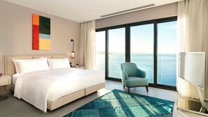 A hotel room with a large bed, a view of the sea, a chair, and a TV. - 4 Bedrooms & 1 Living Room  Pool Villa Seaview (Bodrum)