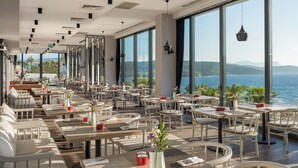A modern restaurant with large windows, tables, and chairs arranged for dining. - 4 Bedrooms & 1 Living Room  Pool Villa Seaview (Bodrum)