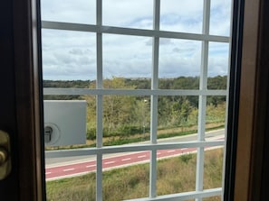 A window with a view of a road and greenery. - Dimora247Elegant 2BR 2BA Apartment in Roma Balduina, peaceful stay near Vaticano (Roma)