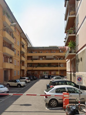A multi-story residential building with balconies, parked cars, and a no parking sign. - Dimora247Elegant 2BR 2BA Apartment in Roma Balduina, peaceful stay near Vaticano (Roma)