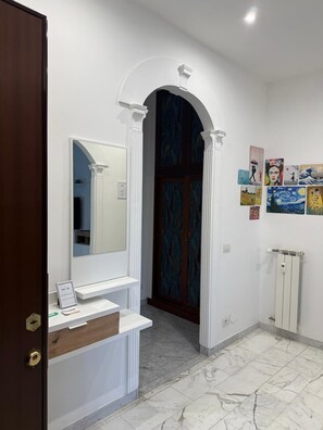 A bathroom with a white vanity, a mirror, a door with a decorative pattern, and a tiled floor. - Dimora247Elegant 2BR 2BA Apartment in Roma Balduina, peaceful stay near Vaticano (Roma)