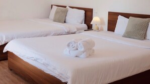 Two neatly made beds with white linens, a lamp on one bed, and a stack of rolled towels on the first bed. - Van Nhi MTV Hotel (Xuan Huong - Da Lat)