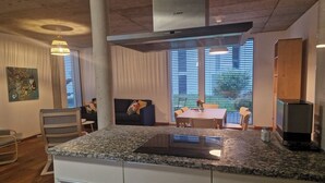 Una cocina moderna con encimera de granito, armarios blancos y extractor Bosch.