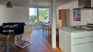 Un espacio de estar moderno con comedor, cocina y ventanas amplias.