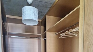 Ein begehbarer Kleiderschrank mit Holzregalen, Schubladen und Platz für hängende Kleidung.