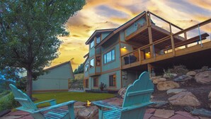 A two-story house with a deck, outdoor seating, and a fire pit. - Downtown Oasis with View, Hot Tub & Fire Pits (Pagosa Springs)