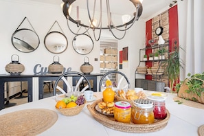 A breakfast setting with wicker baskets, a fruit bowl, and jars of preserves on a table.