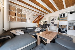 Un salon moderne avec un canapĂ© dâangle, une table basse en bois et des rangements intĂ©grĂ©s.