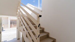 Uma escadaria com corrimão, que leva a um vão aberto.