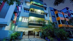 A multi-story building with balconies, a gated entrance, and potted plants. - Alaya Stays Saffron Breeze 4 BHK Apt (Bengaluru)